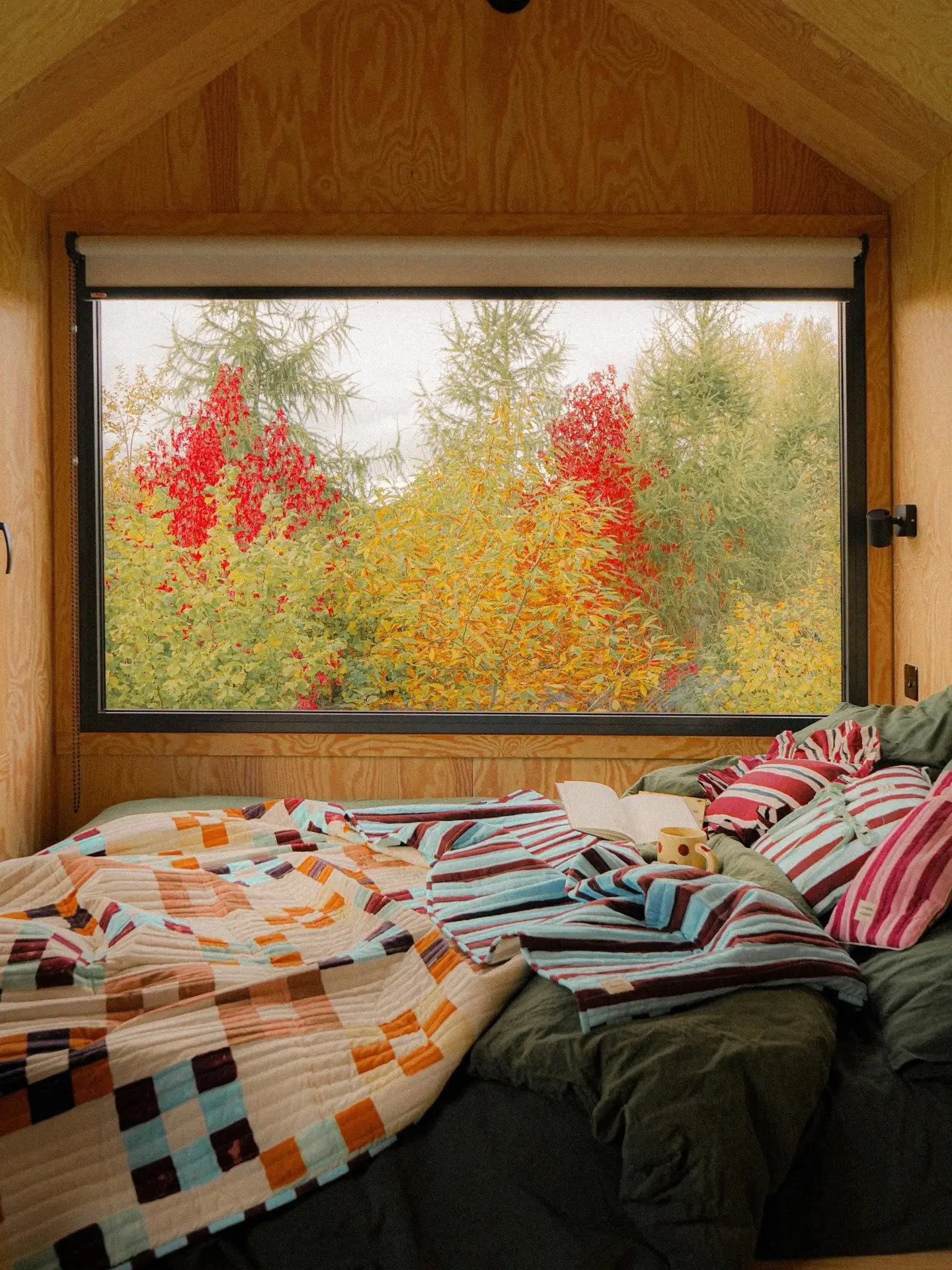 Chambre en bois ouverte sur un paysage d’automne